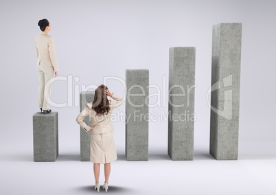 Businesswomen standing and looking at graph against a grey background