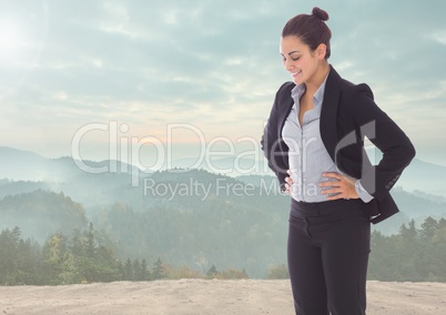 Businesswoman looking down against mountain background