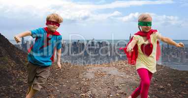 Happy kids wearing red cape and mask having fun against cityscape