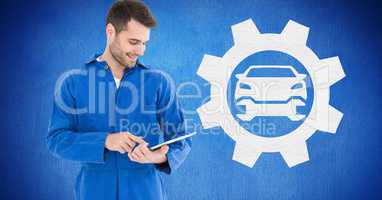 Smiling mechanic using digital tablet against blue background