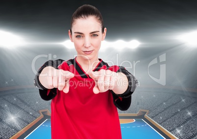 Confident female athlete gesturing against stadium background