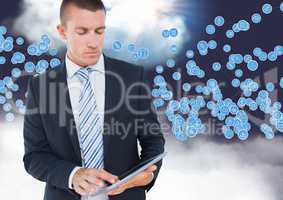 Businessman using digital tablet against technology icons in sky