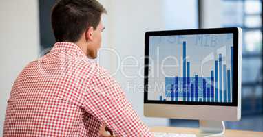 Man using desktop computer displaying a graph chart on screen