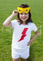 Girl with eye mask standing with hands on hips on grass
