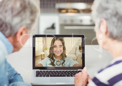 Senior couple having video call with daughter on laptop