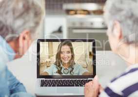 Senior couple having video call with daughter on laptop