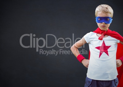 Boy wearing superhero costume standing with hands on hip