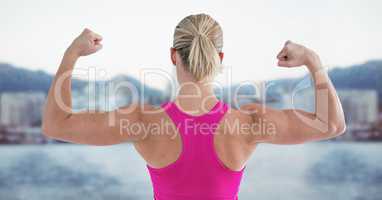 Fit woman flexing muscles against digitally generated background