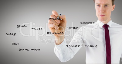 Businessman writing on glass with marker against grey background