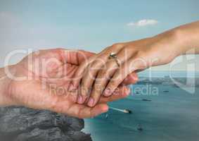 Couple holding hands against sea
