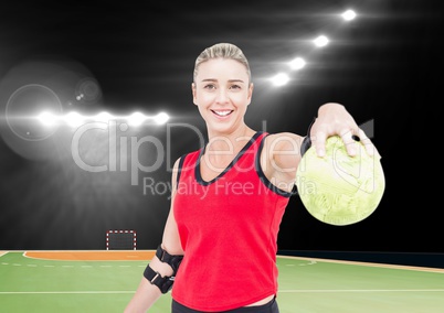 Portrait of happy female handball player holding ball at handball court