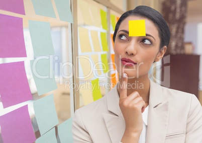 Thoughtful businesswoman with blank sticky note on forehead
