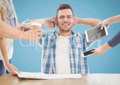 Happy man sitting at desk while colleagues office coffee and electronic devices