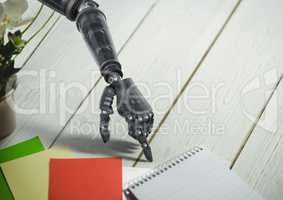 Robot hand pointing at spiral diary on wooden table