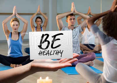 Hand holding card with text be healthy in yoga class