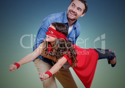 Dad carrying his daughter in superhero costume against green background