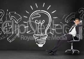 Businessman relaxing on chair against light bulb on blackboard