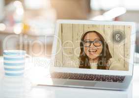 Laptop with smiling woman on video call screen