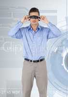 Man using virtual reality headset against cog wheel background