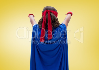 Girl wearing superhero costume standing against yellow background