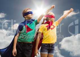 Two children wearing superhero costume standing against sky background