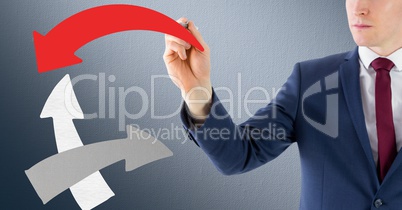 Businessman drawing arrow sign against grey background