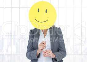 Businesswoman holding happy smiley face in front of her face against white background