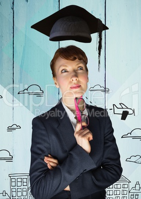 Thoughtful businesswoman with mortar hat holding spectacles against wooden background