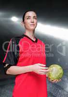 Athlete holding handball against stadium in background