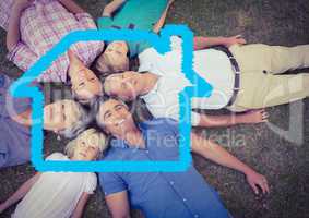 Family lying on grass overlaid with house shape