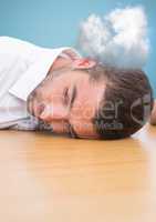 Man resting his head with on desk with cloud in background