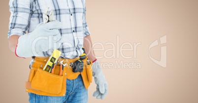 Handy man standing with tools against beige background