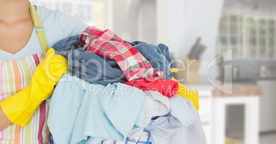 CleanerMid section of woman with apron holding a laundry basket