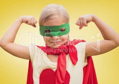 Girl in superhero costume showing fists against yellow background