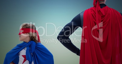 Dad and daughter in superhero costume with their hands on hips standing