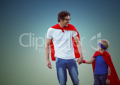 Happy father and son in red cape and mask holding hands while walking