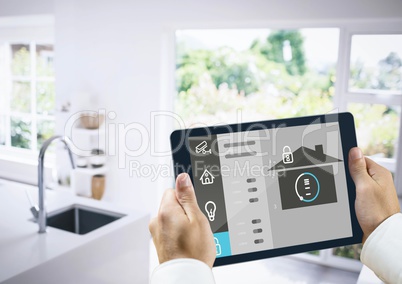 Hands holding digital tablet with home security icons