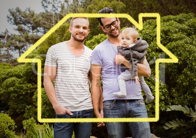Homosexual couple standing with their son against house outline