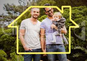 Homosexual couple standing with their son against house outline