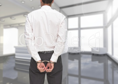 Rear view of corrupt businessman in hand cuffs