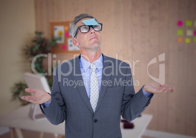 Confused businessman with sticky notes stuck on his forehead