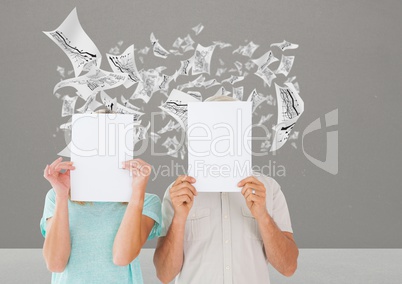 Couple holding blank placard against data graphs in background