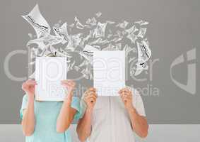Couple holding blank placard against data graphs in background