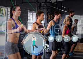 Fit people performing jump ropes in gym against fitness interface in background