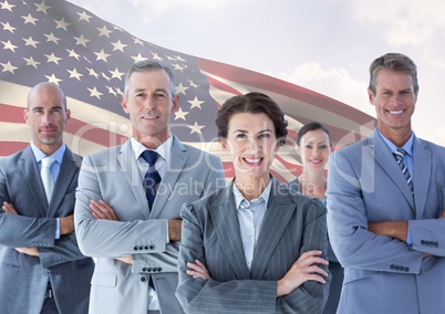 Group of confident businesspeople standing against American flag