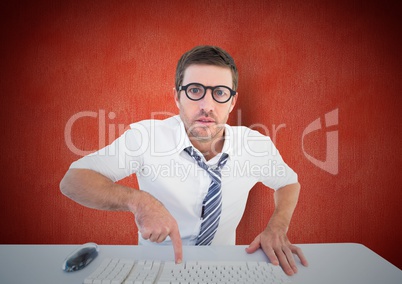 Confused man pointing to computer keyboard at desk