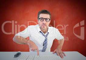 Confused man pointing to computer keyboard at desk