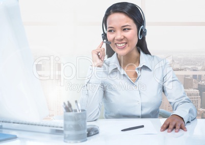 Call center executive sitting at desk and talking on headphones