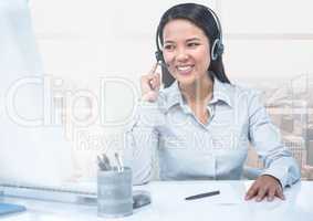 Call center executive sitting at desk and talking on headphones