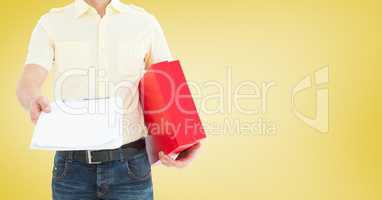 Delivery man holding a parcel and clipboard against yellow background